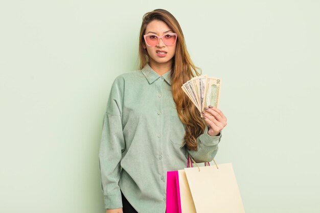 Asian pretty woman feeling puzzled and confused. shopping bags concept