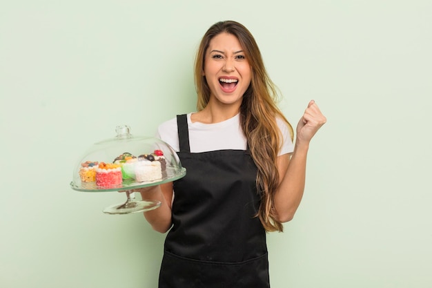 asian pretty woman feeling shocked,laughing and celebrating success. home made cakes concept