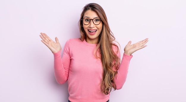 Asian pretty woman looking happy and excited shocked with an unexpected surprise with both hands open next to face