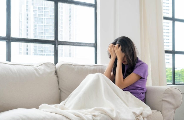 Asian pretty young woman sitting alone on couch with feeling sadness emotional young woman was depressed on sofa