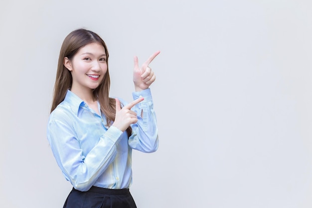 Asian professional business woman who has long hair with a blue shirt smiles present something