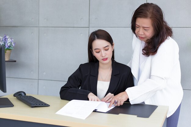 Asian professional female is working and pointing on the paper or document to discuss