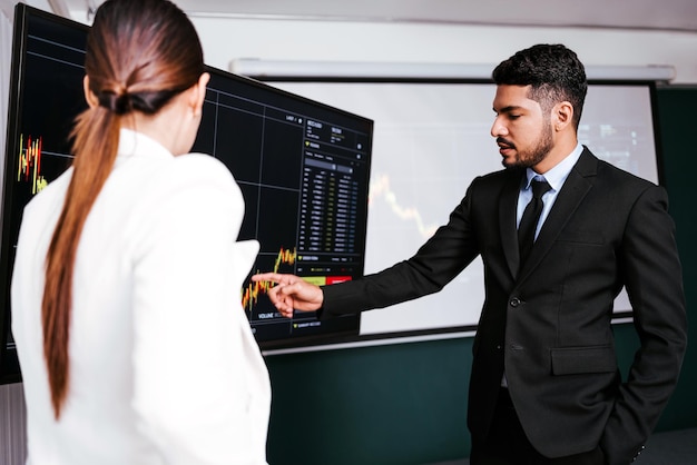 Asian professional successful businessman pointing stock or crypto graph on the monitor screen