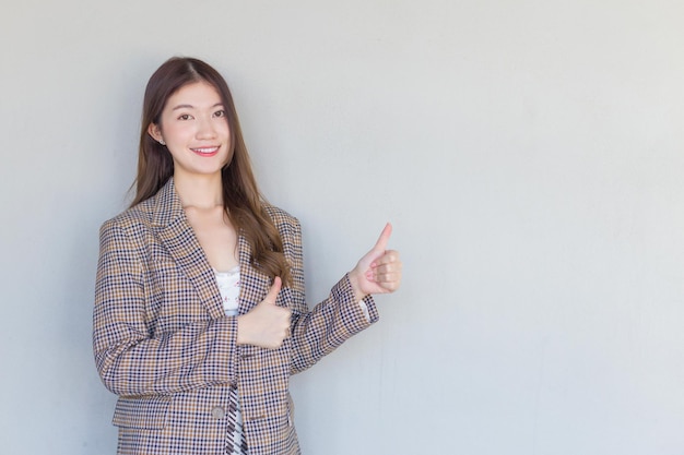 Asian professional woman with black long hair wearing plaid suit and pretty smiling look at camera