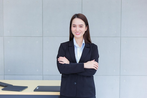 Foto la donna lavoratrice professionista asiatica che ha i capelli lunghi indossa un abito formale nero con camicia blu.