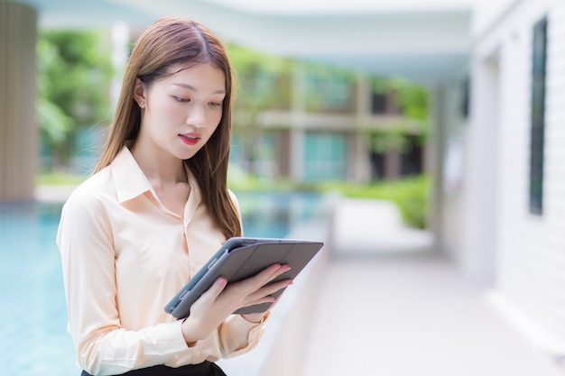 La giovane donna lavoratrice asiatica professionale utilizza il tablet per cercare i dati nel lavoro da qualsiasi punto del concetto.