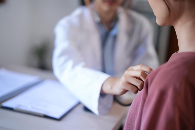 Asian psychologist women using stethoscope to check up patient and giving counseling about medicine and mental health therapy while female patient stress and anxiety with psychological health problem