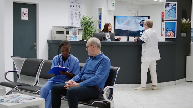 Asian receptionist working at hospital reception counter,\
helping doctor with appointments and patients. medical worker\
preparing healthcare consultations and checkup visits in waiting\
area.