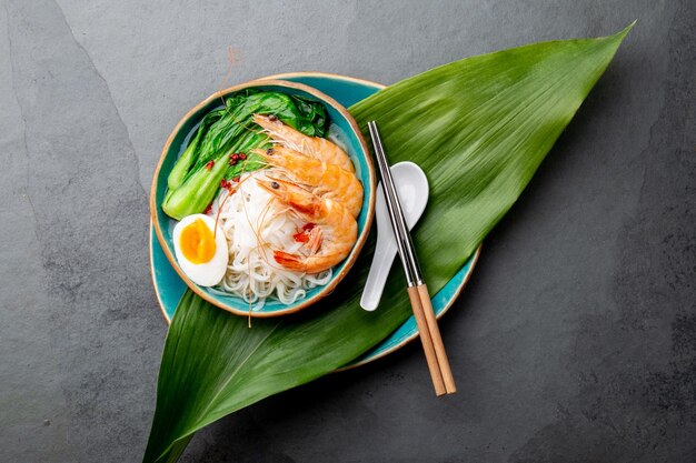 Asian rice noodles with shrimps on gray background