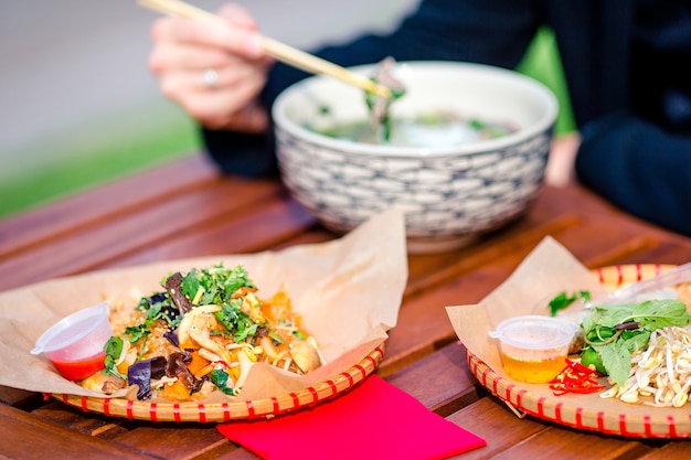 Foto tagliatelle di riso asiatiche con verdure e sause close-up sul tavolo