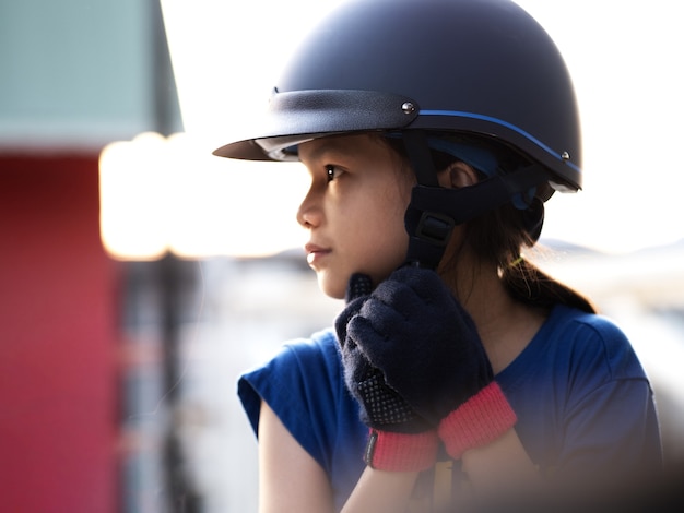 馬、乗馬、または馬の牧場での乗馬の練習をしているアジアの学校の子供の女の子。