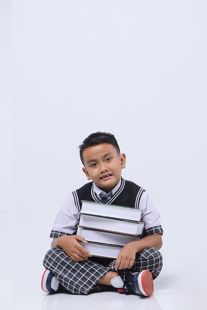 Asian schoolboy with books for education portrait on a white studio background.