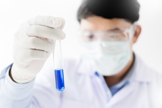 Asian scientific researcher working in laboratory holds test tube in hand a liquid solution analysis using chemical manufacturing.