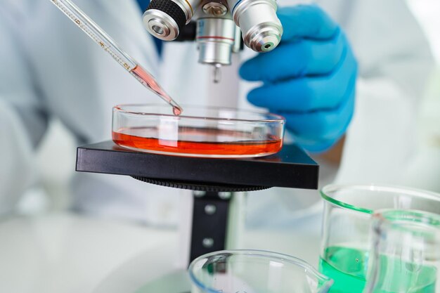 Asian scientist biochemist or microbiologist working research with a microscope in laboratory For protect outbreak Coronavirus Covid19 bacteria and germs