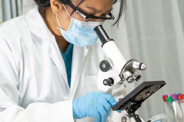 Photo asian scientist biochemist using microscope