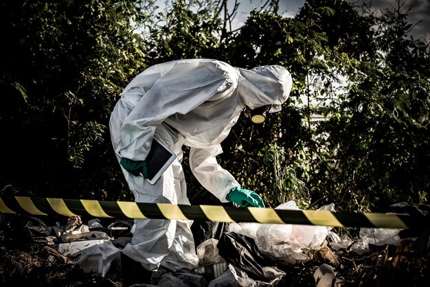 Photo asian scientist wear chemical protection suit check danger chemicalworking at dangerous zonecollecting samples in case of corona virus investigation outbreaked from china