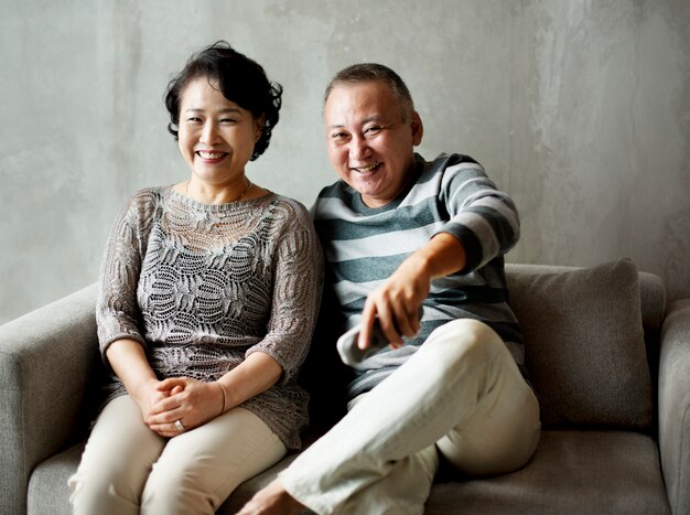 Asian senior couple sitting together at sofa