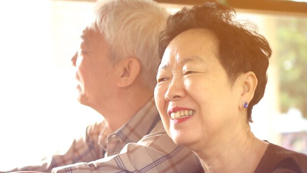 写真 アジアの高齢の夫婦は朝の窓から吹く風で公共交通機関に乗るのを楽しんでいます