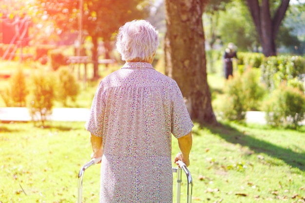 Asian senior or elderly old lady use walker with strong health while walking at park.