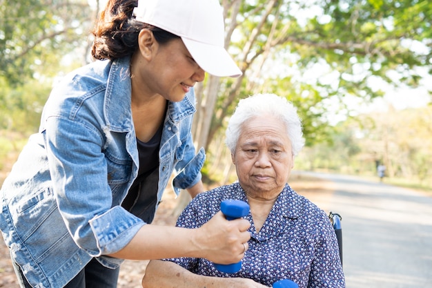 Asian senior or elderly old lady woman exercise with dumbbell in park.