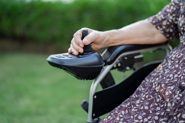 Asian senior or elderly old lady woman patient on electric wheelchair with remote control at nursing hospital ward, healthy strong medical concept