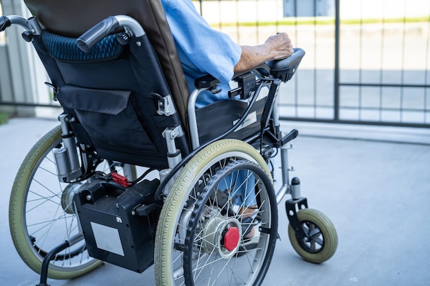 Asian senior or elderly old lady woman patient on electric wheelchair with remote control at nursing hospital ward healthy strong medical concept