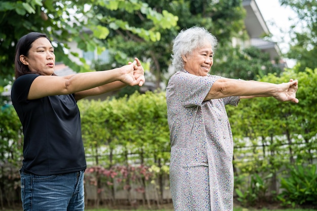 アジアの高齢者または高齢者の老婦人女性患者の運動を幸せで新鮮な公園で健康的な強力な医療コンセプトをお楽しみください