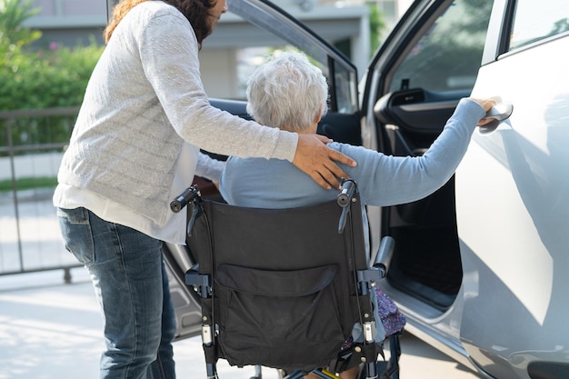 車椅子に座っているアジアのシニアまたは高齢の老婦人女性患者は、彼女の車に健康で強力な医療コンセプトを取得する準備をします
