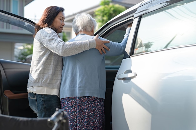 車椅子に座っているアジアのシニアまたは高齢の老婦人女性患者は、彼女の車に健康で強力な医療コンセプトを取得する準備をします