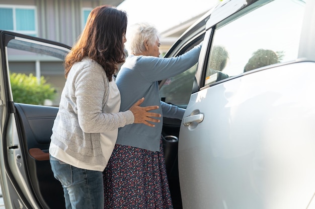 Asian senior or elderly old lady woman patient sitting on wheelchair prepare get to her car healthy strong medical concept