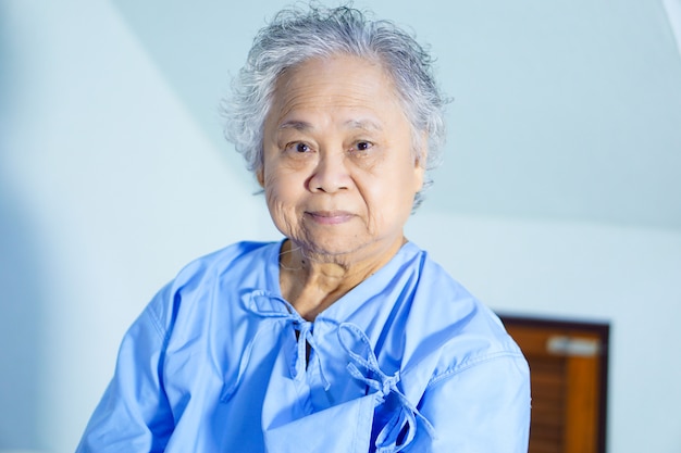 Asian senior or elderly old lady woman patient smile bright face in nursing hospital ward.