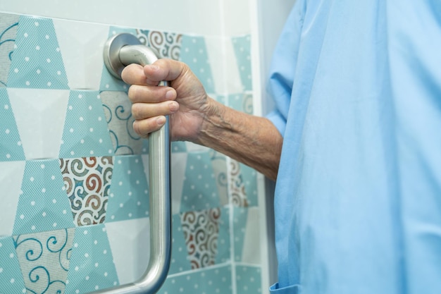 Азиатская пожилая или пожилая женщина-пациентка пользуется туалетом, ванной, ручкой безопасности в больничной палате, здоровая сильная медицинская концепция