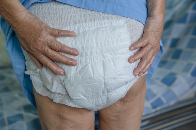 Foto paziente asiatico anziana o anziana donna che indossa pannolino per incontinenza nel reparto ospedaliero di cura, concetto medico sano e forte.