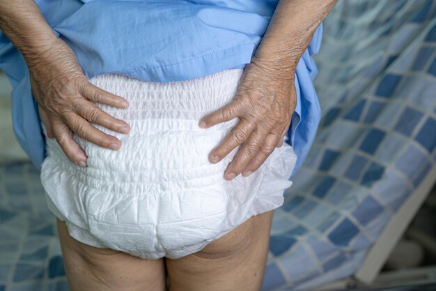 Foto paziente asiatico anziano o anziano che indossa un pannolino per incontinenza nel reparto di cura dell'ospedale, concetto medico sano e forte.