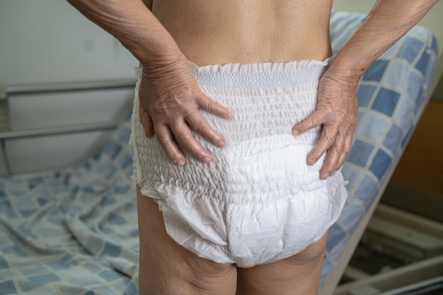 asian senior or elderly old lady woman patient wearing incontinence diaper in nursing hospital ward healthy strong medical concept