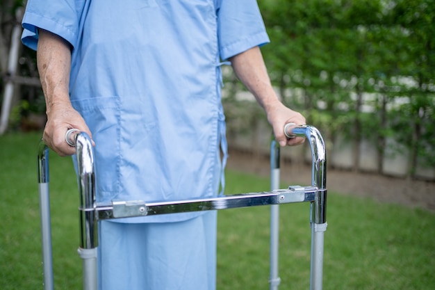 Photo asian senior or elderly old lady woman use walker with strong health while walking at park in happy fresh holiday.