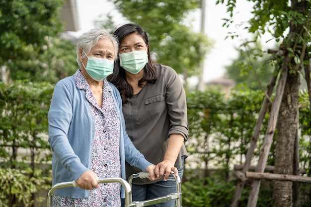 Donna anziana anziana o anziana asiatica che indossa una maschera facciale nuova normalità nel parco per proteggere l'infezione di sicurezza covid-19 coronavirus.