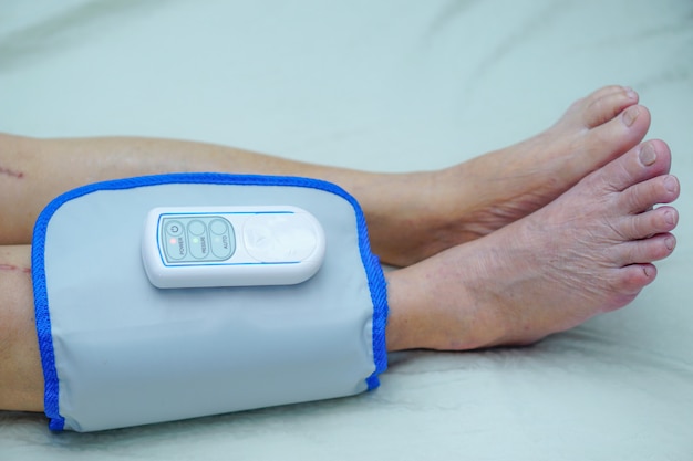 Азиатский пациент пожилой или пожилой женщины с аккумуляторным компрессионным массажем ног Massa