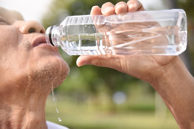 Asian senior male drinking water.