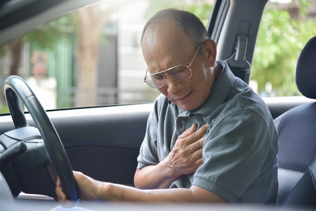 Uomo senior asiatico che ha attacco di cuore.