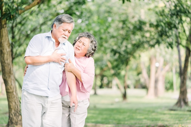 Asian senior man holding his chest and feeling pain 