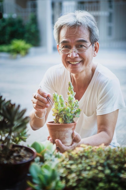 Foto sorriso a trentadue denti dell'uomo anziano asiatico con la faccia di felicità nel giardino di casa