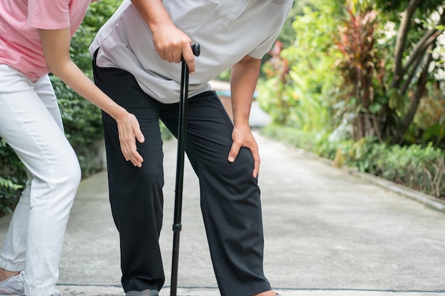 Asian senior man walking in the backyard and painful inflammation and stiffness of the joints