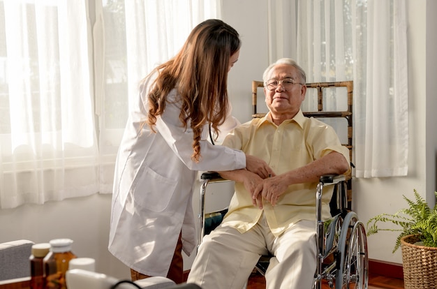 Asian senior man was sick and sitting on wheelchair. the doctor check retirement age health at home.