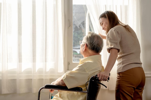 Photo asian senior man was sick and sitting on wheelchair. retirement age lifestyle and togetherness with family at home.