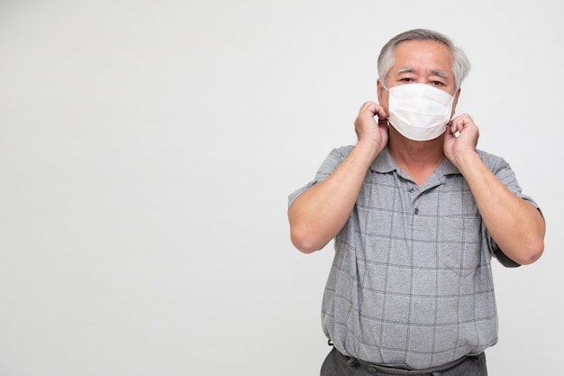 Uomo senior asiatico che indossa una maschera protettiva per coronavirus della peste