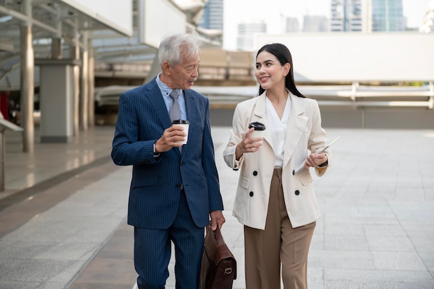 Asian senior mature middle aged businessman and young businesswoman having a discussion