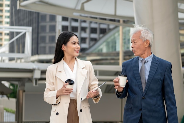 Asian senior mature middle aged businessman and young businesswoman having a discussion