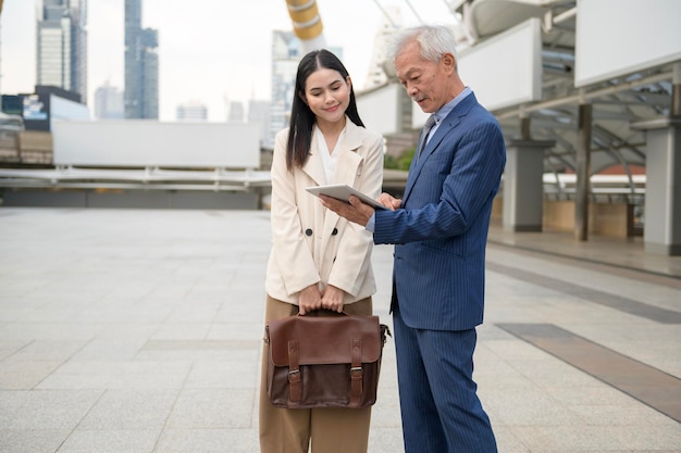 Asian senior mature middle aged businessman and young businesswoman having a discussion