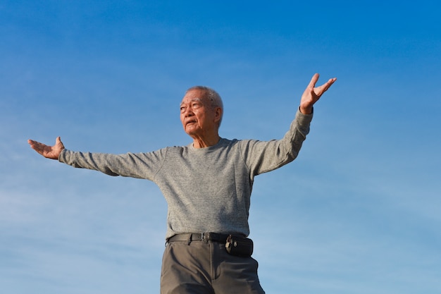 Фото Азиатский старший старик практикует тайцзицюань китайское кунг-фу на пляже
